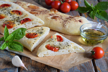 Traditional Italian Focaccia with tomatoes, basil, garlic and sumach. Homemade pastry. Flat bread. Organic flatbread. Rustic style.
