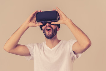 Portrait of excited and amazed young man wearing Virtual Reality headset exploring 3D world