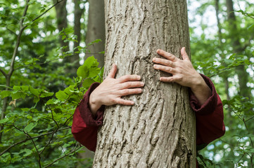 closeup of woman hugging a tree in a forest