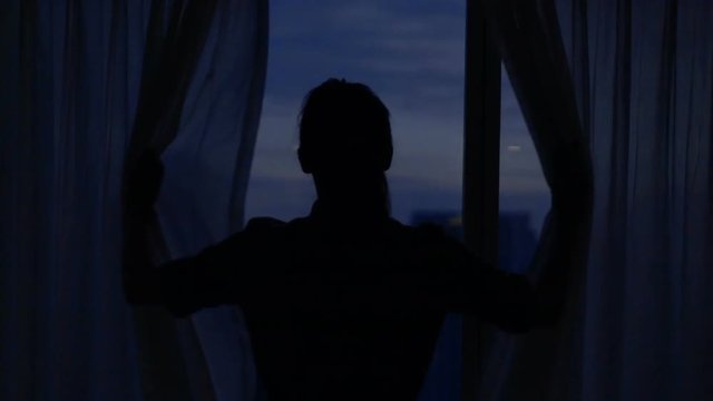 Young woman unveil curtains and admire view from window, super slow motion