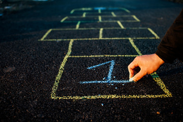 A young man draws hopscotch on asphalt. Good mood and spring in Russia. A bearded man recalls his childhood.