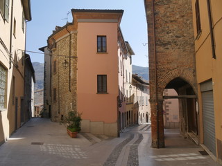 Typical street in Bobbio. They were built in Medieval age with Trebbia river stones. - obrazy, fototapety, plakaty