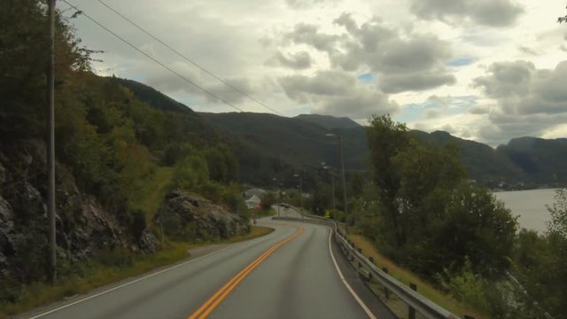 View of a vehicle crossing a long tunnel, with a yellowish illumination, Norway. Amazing realtime countryside view from a tour bus.