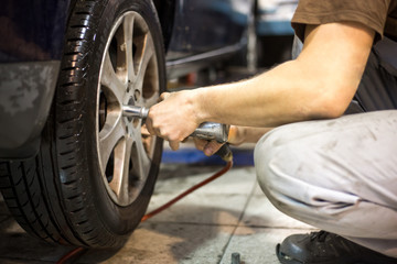 Obraz premium Professional car servis man changing the wheel of car