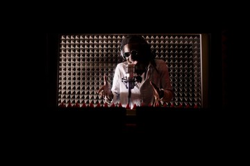 African musician sings into a microphone in a recording Studio