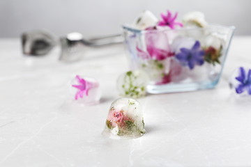 Composition with floral ice cubes on table, space for text