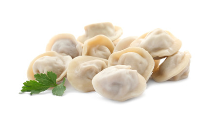 Pile of boiled dumplings with parsley leaves on white background