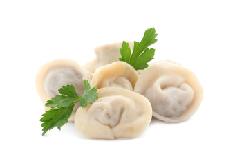 Pile of boiled dumplings with parsley leaves on white background