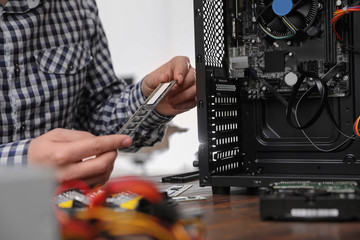 Male technician repairing computer at table, closeup