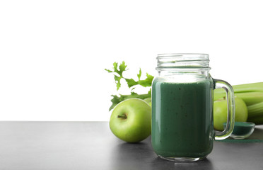 Composition with mason jar of spirulina smoothie on table against white background. Space for text
