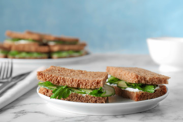 Plate with traditional English cucumber sandwiches on table. Space for text
