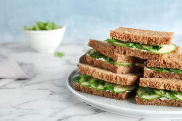 Plate with traditional English cucumber sandwiches on table. Space for text