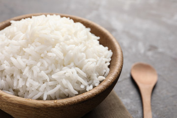 Bowl of tasty cooked rice served on table, closeup. Space for text