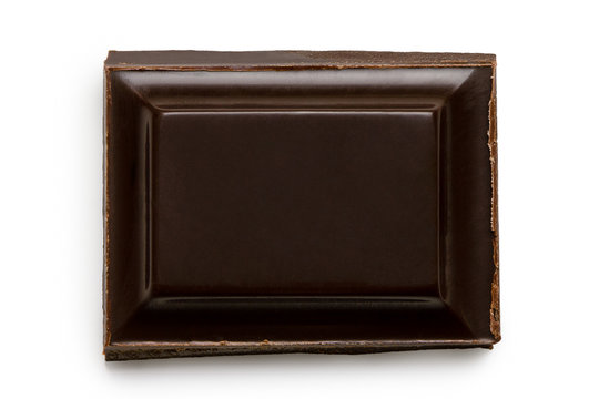 Single square of dark chocolate isolated on white from above.
