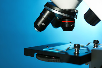 Modern microscope with different lenses on color background, closeup. Chemical research