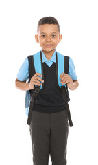 Portrait of cute African-American boy in school uniform with backpack on white background