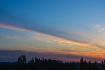 Landscape with dramatic light - beautiful golden sunset with saturated sky and clouds.
