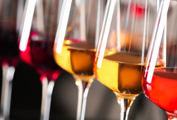 Row of glasses with different wines on blurred background, closeup