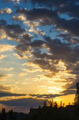 Landscape with dramatic light - beautiful golden sunset with saturated sky and clouds.