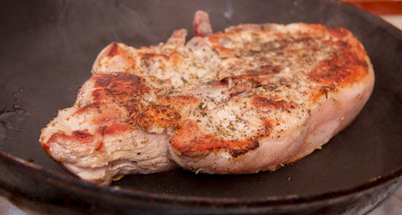 Roasted steak on the frying pan in the kitchen