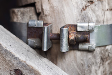 old metal part with screw connection on wooden wall background