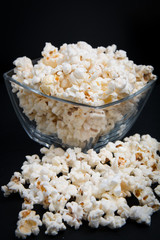 popcorn in a glass bowl on a black background