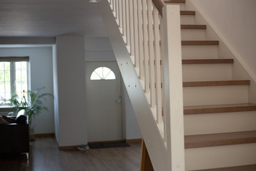 Obraz premium White wooden stairs in white house interior