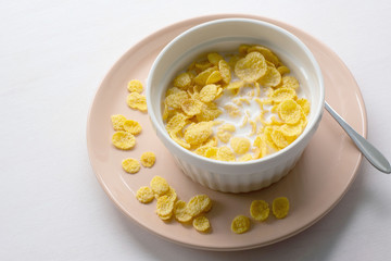 Healthy breakfast with cornflakes and milk over white background