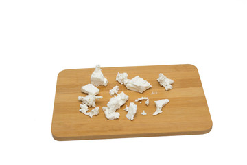 Feta cheese on wooden board, top view