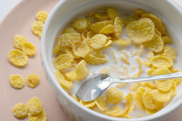Healthy breakfast with cornflakes and milk over white background