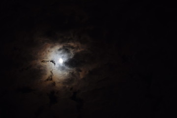 Obraz na płótnie Canvas The night sky, moon hiding behind the clouds