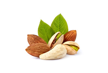 Pistachio nuts wits cashew, almonds and leaves in closeup isolated