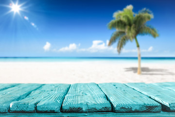 Wooden desk of free space and summer beach with palms 
