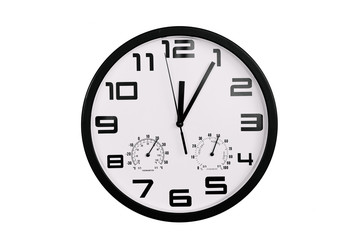 simple classic black and white round wall clock isolated on white. Clock with arabic numerals on wall shows 12:05 , 00:05