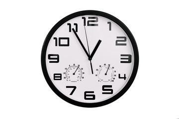 simple classic black and white round wall clock isolated on white. Clock with arabic numerals on wall shows 12:55 , 00:55