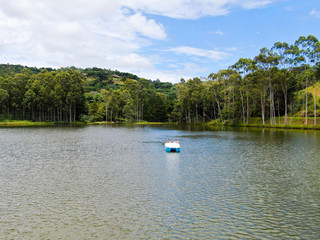 Fototapeta na wymiar Aerial view of beautiful little wood cabana next the lake in tropical mountain, with family enjoying relax sun moment, swimming and fishing. Monte Alegre Do Sul, Brazil. 