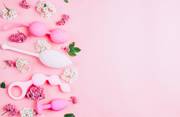 Different sex toys set on a pink background.
