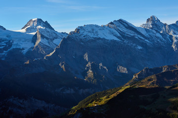 The morning panorama of the mountains with the peaks and mountainsides illuminated by sunlight in Lauterbrunnen valley in Switzerland.