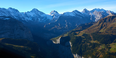 Naklejka na ściany i meble Panoramic view of the mountains at sunrise in Lauterbrunnen valley in Switzerland.