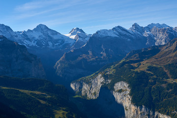 The morning panorama of the mountains with the peaks and rocks illuminated by sunlight in Lauterbrunnen valley in Switzerland.
