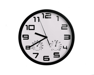simple classic black and white round wall clock isolated on white. Clock with arabic numerals on wall shows 9:40 , 21:40