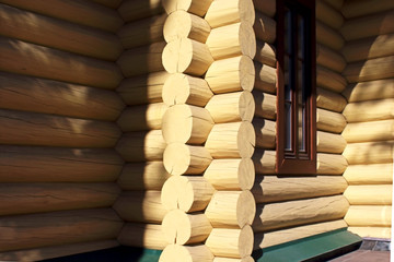 Corner  and wall of a wooden log house made of logs in the village