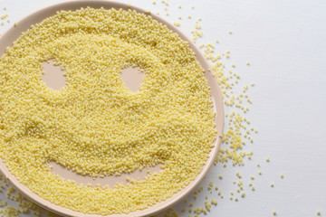 Dry couscous on a plate on a white background. Spilled couscous.