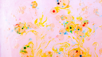 Fluid art. Multicolored background with oil on liquid. Abstract golden pink background on liquid. Pattern with multicolored spots