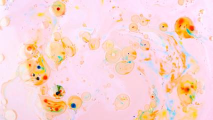 Fototapeta na wymiar Fluid art. Multicolored background with oil on liquid. Abstract golden pink background on liquid. Pattern with multicolored spots