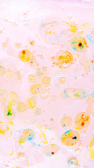 Fluid art. Multicolored background with oil on liquid. Abstract golden pink background on liquid. Pattern with multicolored spots