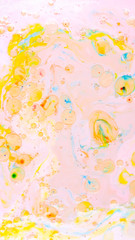 Fluid art. Multicolored background with oil on liquid. Abstract golden pink background on liquid. Pattern with multicolored spots