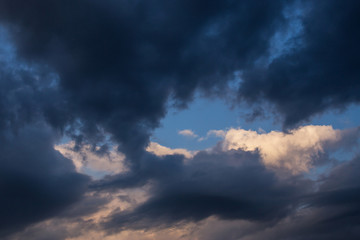 Naklejka na ściany i meble Epic dramatic storm dark clouds against blue sky background. Darkness and light, heaven