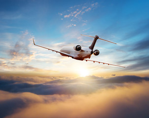 Private jet plane flying in sunset