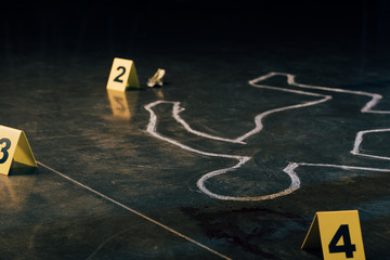selective focus of chalk outline and evidence markers at crime scene - obrazy, fototapety, plakaty